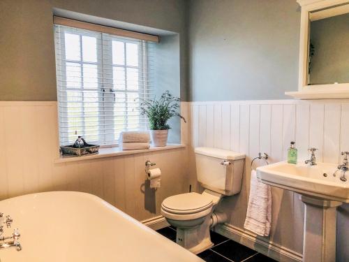 a bathroom with a tub and a toilet and a sink at Penlaurel in Launceston
