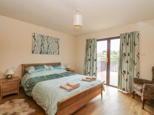 sypialnia z łóżkiem i przesuwnymi szklanymi drzwiami w obiekcie Burnside Lodge Lodge 1, Glengoulandie w mieście Aberfeldy