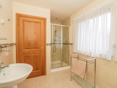 een badkamer met een bad, een wastafel en een douche bij Burnside Lodge Lodge 1, Glengoulandie in Aberfeldy