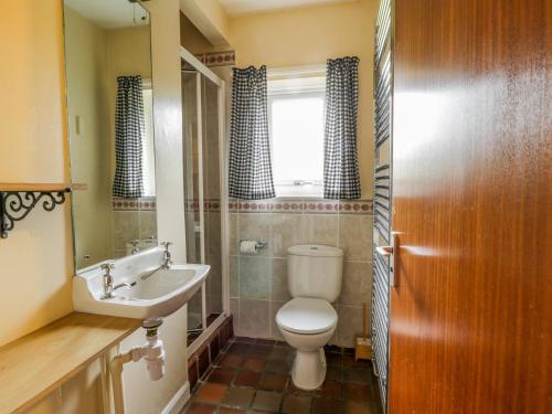 a bathroom with a toilet and a sink at Brackenber Lodge in Hilton