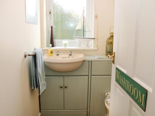 a small bathroom with a sink and a window at Cable House in Cemaes Bay