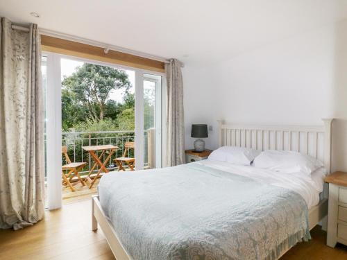 a bedroom with a bed and a sliding glass door at Crift Farm Cottage in Bodmin