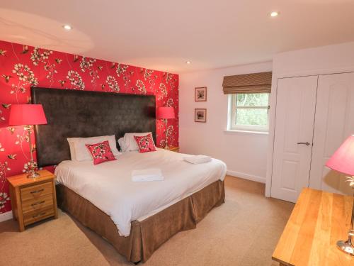 a bedroom with a large bed with red walls at Farley in Matlock