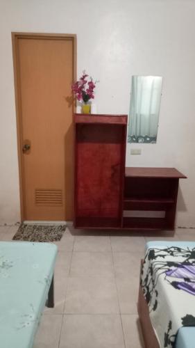 a room with a dresser and a mirror and a door at Aloha in Oslob