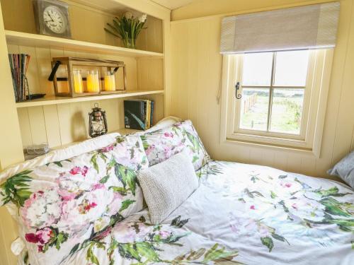 a room with a couch and a window with flowers at Moor Skies in Keighley