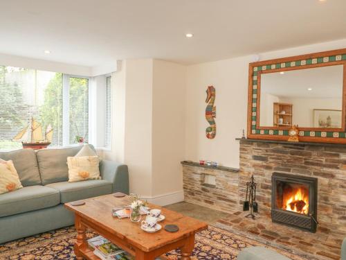 a living room with a couch and a fireplace at Mount Pleasant in Boscastle