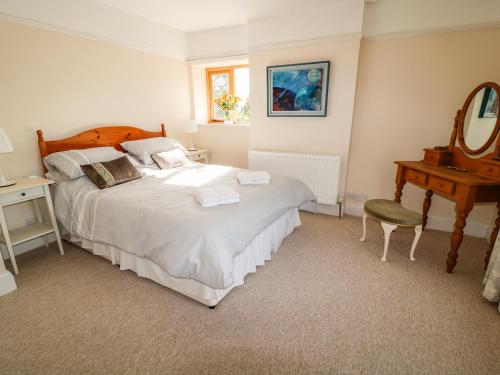 een slaapkamer met een bed, een tafel en een spiegel bij Clearview in Lydford