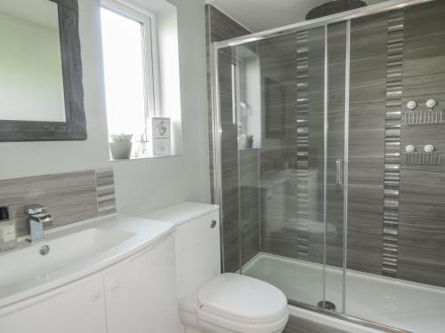 uma casa de banho com um chuveiro, um WC e um lavatório. em Yew Fold em Soutergate