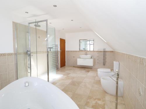 a bathroom with two toilets and a shower and a sink at 20 Ulwell Road in Swanage