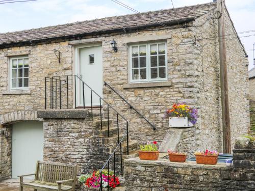 a stone house with flowers in front of it at The Hayloft in Hawes