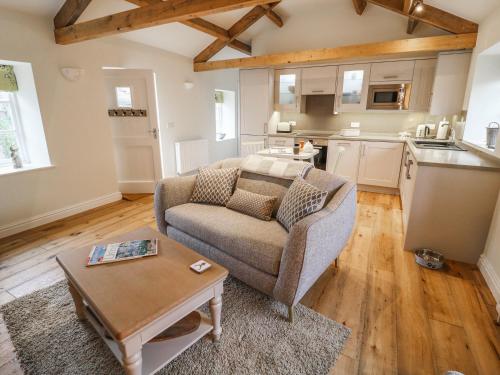 a living room with a couch and a table at The Hayloft in Hawes
