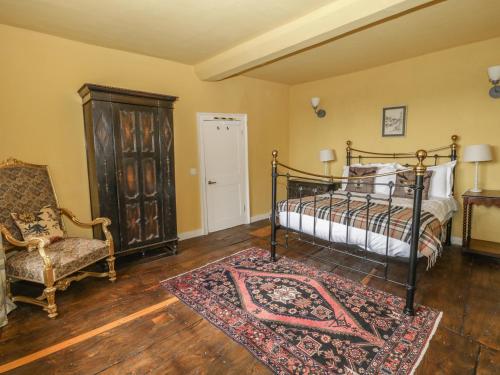 a bedroom with a bed and a chair and a rug at Castle House in Taunton