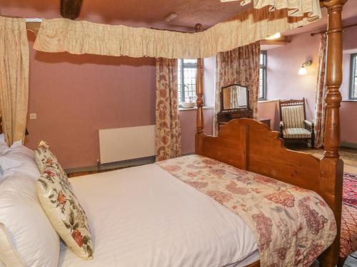 a bedroom with a canopy bed and a chair at Castle House in Taunton
