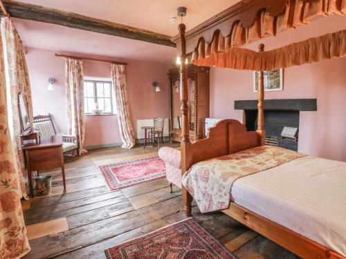 a bedroom with a four poster bed and a fireplace at Castle House in Taunton