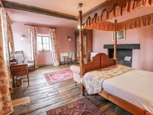 - une chambre avec un lit à baldaquin et une cheminée dans l'établissement Castle House, à Taunton