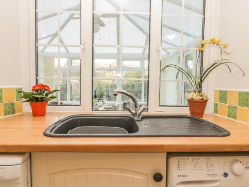 eine Küche mit einem Waschbecken und einem Fenster in der Unterkunft Yew Court Cottage in Scarborough