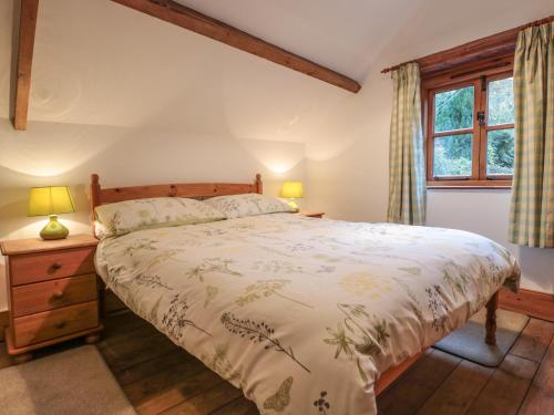 a bedroom with a large bed and a window at Happy Cow in Coleford