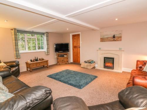 a living room with a couch and a fireplace at Fisher Granary in Lampeter
