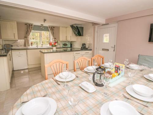 a kitchen with a table with plates and glasses on it at Fisher Granary in Lampeter