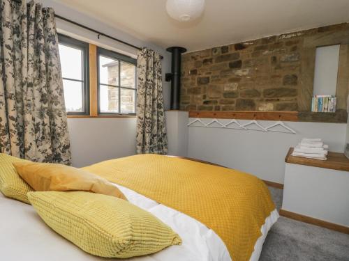 a bedroom with a bed with yellow and white pillows at The Greenhouse in Skipton