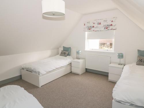 a bedroom with two beds and a window at Sandpipers in Anstruther