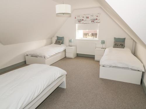 a bedroom with two beds and a window at Sandpipers in Anstruther