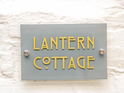 
a sign on a wall with a blue and white sign at Lantern Cottage, Padstow in Padstow

