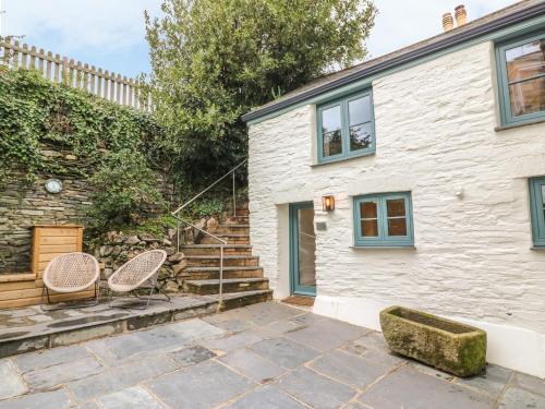 a house with two chairs and stairs in front of it at Lantern Cottage in Padstow