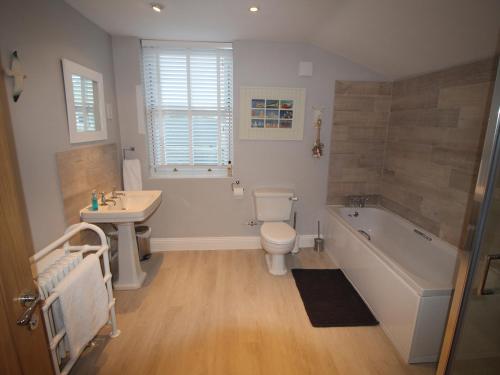 uma casa de banho com uma banheira, um WC e um lavatório. em Alpen Rose Cottage em Portland