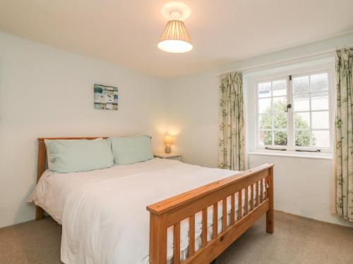a bedroom with a large bed and a window at Willets Cottage in Bideford