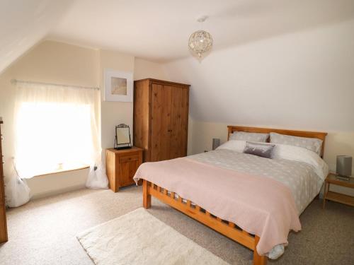 Un dormitorio con una cama grande y una ventana en Manor Farm House Cottage, en Kettering