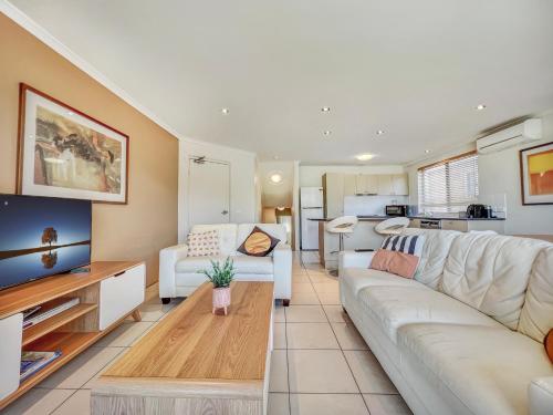 a living room with a couch and a table at Seachange Apartments Merimbula in Merimbula