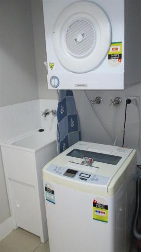 a small refrigerator with a fan on top of it at Edge Apartments Cairns in Cairns