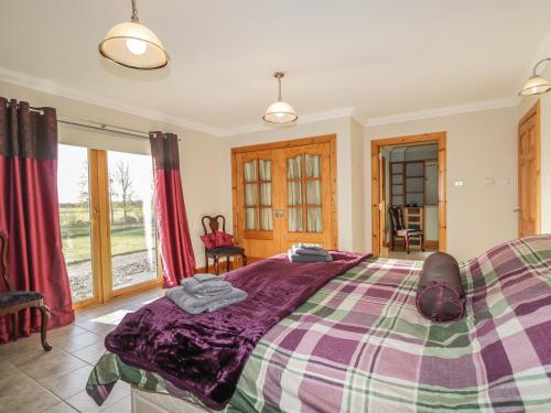 a bedroom with a large bed with a purple blanket at The Glebe in Invergordon