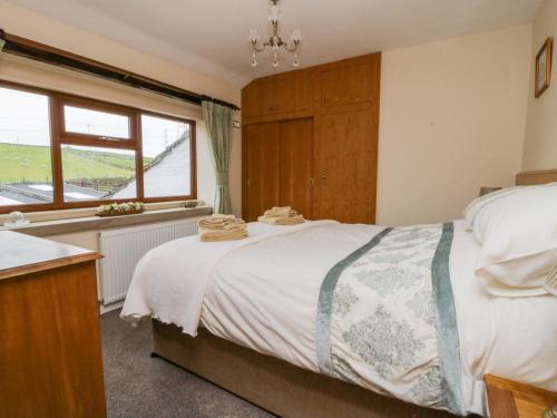 Un dormitorio con una cama grande y una ventana en Acorn Cottage, en Bradford