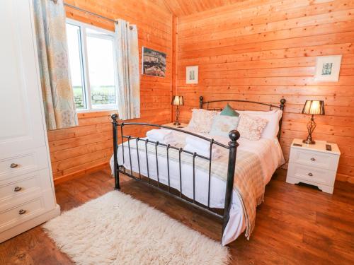 een slaapkamer met een bed in een houten wand bij Borah Lodge in Penzance