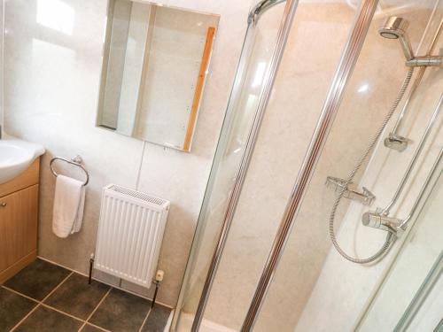 een badkamer met een douche met een glazen deur bij Borah Lodge in Penzance
