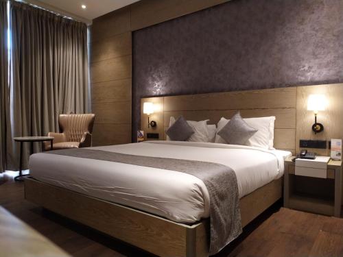 a hotel room with a large bed and a desk at MothiMahal Residency Thrissur in Trichūr