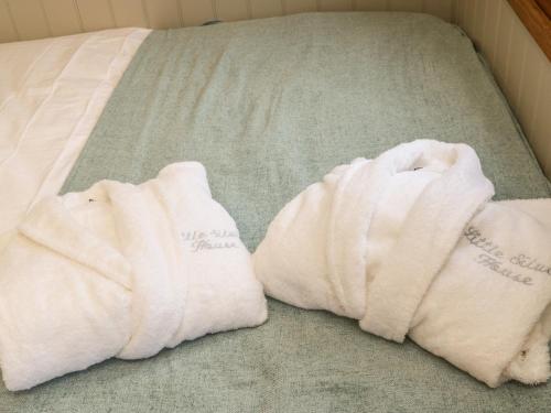 two white towels sitting on top of a bed at Little Silver Leaf in High Bickington