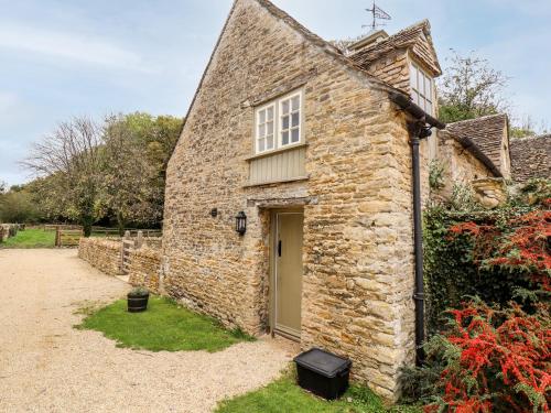 an old stone house with a door and a yard at The Clock Tower in South Cerney