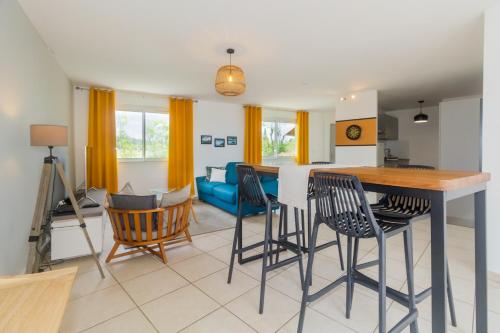 cocina y sala de estar con mesa y sillas en Cap Homard - spacieux apt - magnifique vue mer -proche plage en Saint-Gilles-les-Bains