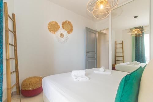 Habitación blanca con 2 camas y espejo. en Cap Homard - spacieux apt - magnifique vue mer -proche plage, en Saint-Gilles-les-Bains