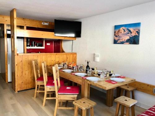 une salle à manger avec une table en bois avec des chaises et un buffet dans l'établissement Appartement pour 10 personnes au cœur des Arcs 1800 - Duplex 4 Pièces 10 personnes MAE-5001, à Arc 1800