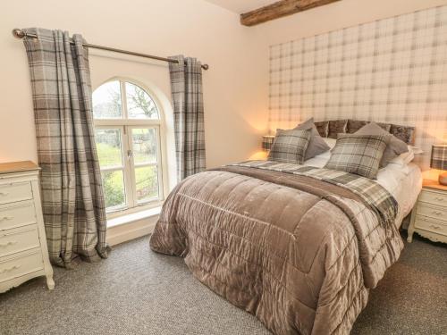 a bedroom with a bed and a window at Orchard Barn in Stone