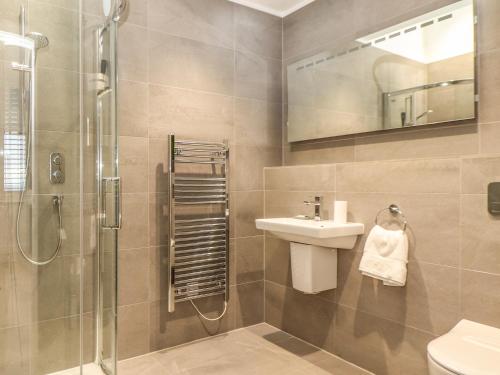 a bathroom with a sink and a shower and a toilet at Praa Waves in Penzance