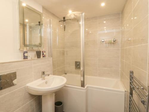 a bathroom with a sink and a tub and a shower at 2 Riverside Walk in Airton