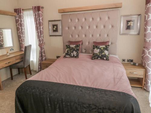 ein Schlafzimmer mit einem großen Bett und einem Schreibtisch in der Unterkunft Avonal Lodge 24 in Perth