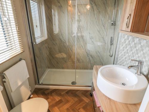 ein Bad mit einer Dusche und einem Waschbecken in der Unterkunft Avonal Lodge 24 in Perth