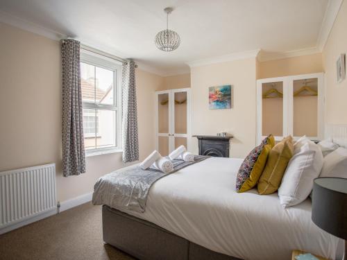 a bedroom with a large bed and a window at Wey Cottage in Weymouth