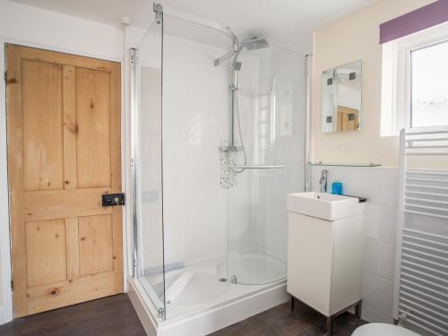 a bathroom with a shower and a toilet and a sink at Wey Cottage in Weymouth